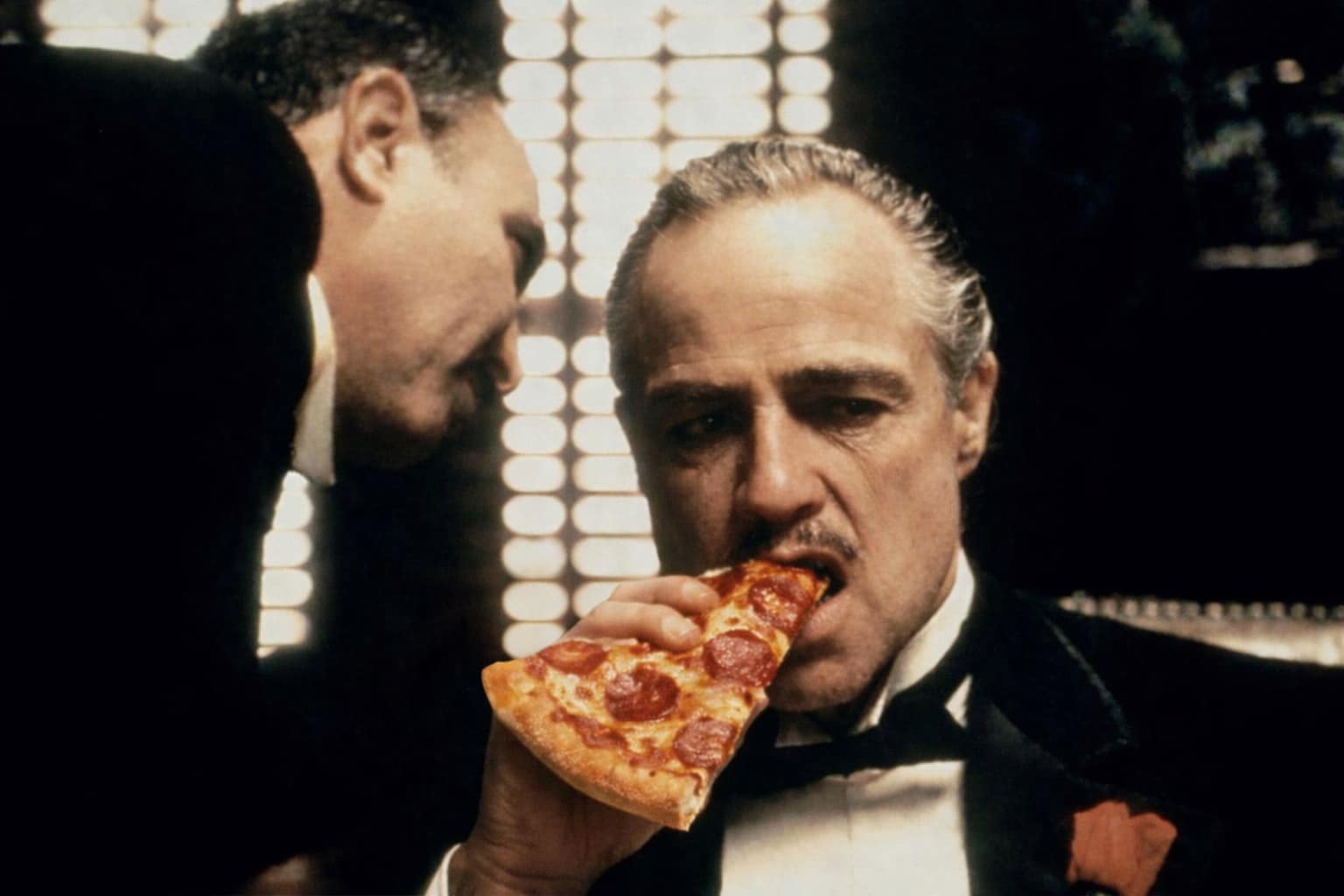Movie-inspired artwork of a suited man eating a pizza slice