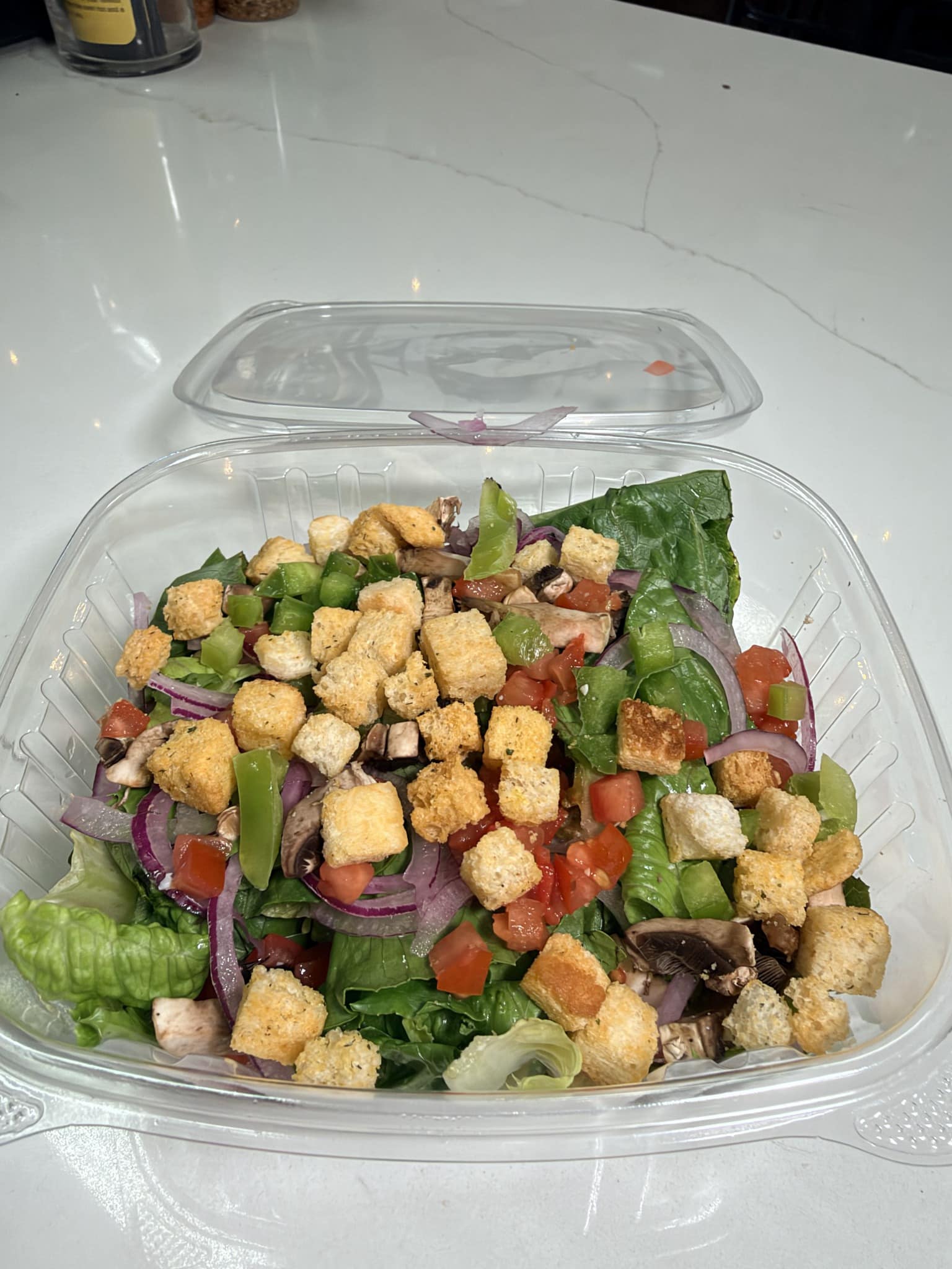 Veggie salad with lettuce, tomatoes, green peppers, red onion, mushrooms and croutons