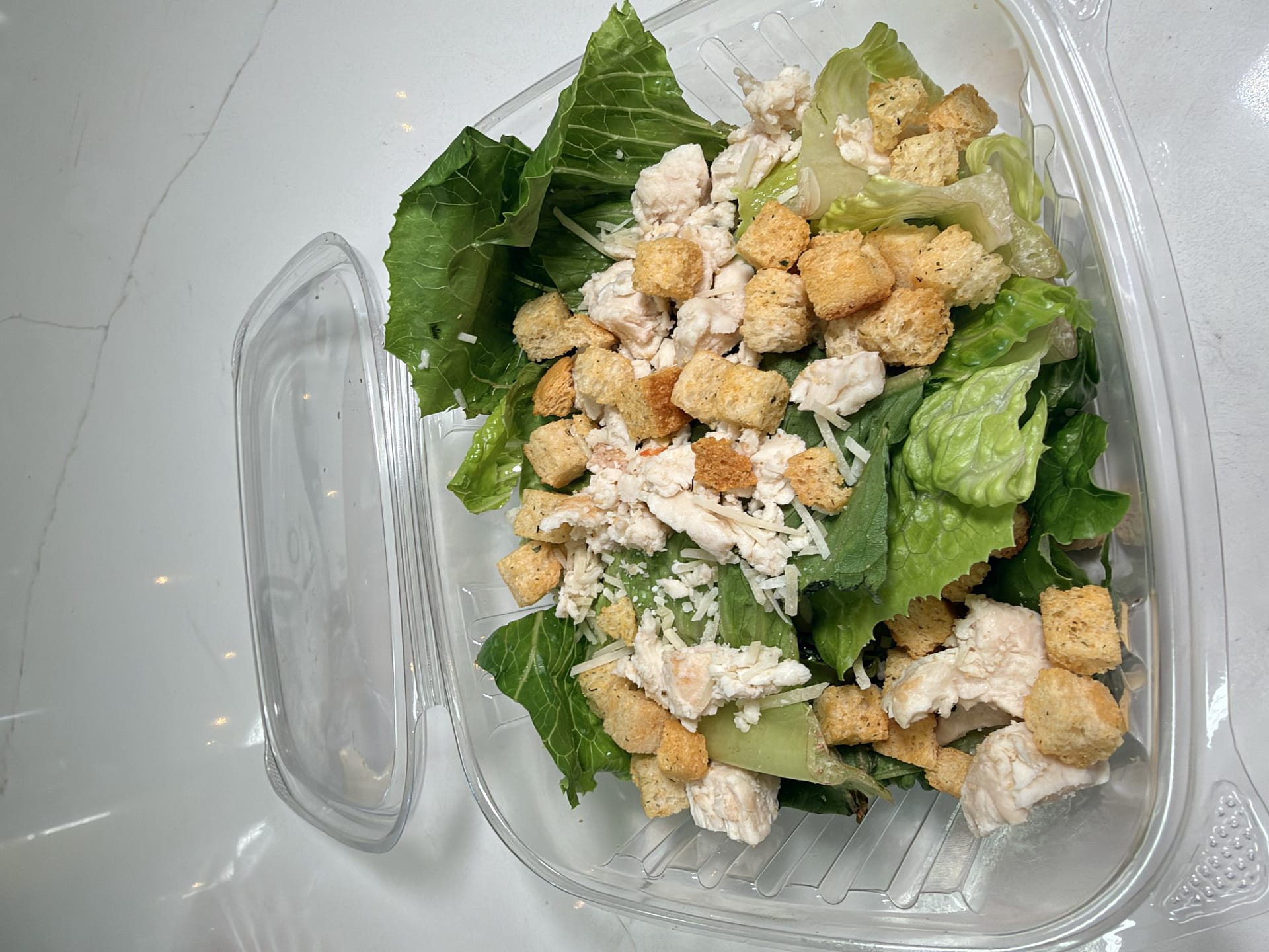 Chicken Caesar salad with romaine lettuce, chicken, grated cheese and croutons